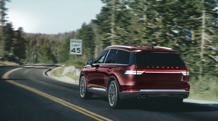 A 2024 Lincoln Aviator® SUV is being driven on a winding mountain road | Bondy's Lincoln in Dothan AL