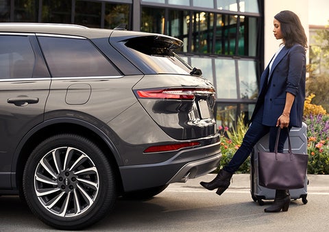 A woman with her hands full uses her foot to activate the available hands-free liftgate. | Bondy's Lincoln in Dothan AL