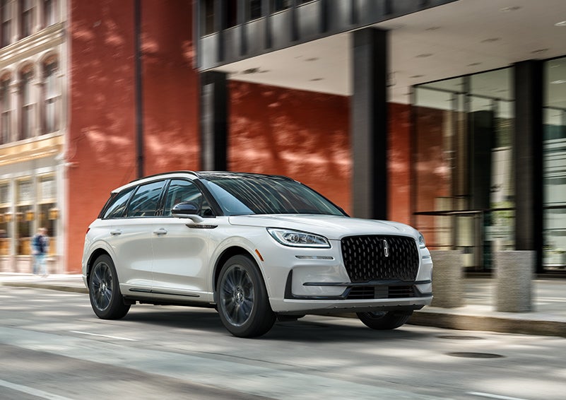 The 2024 Lincoln Corsair® SUV with the Jet Appearance Package and a Pristine White exterior is parked on a city street. | Bondy's Lincoln in Dothan AL