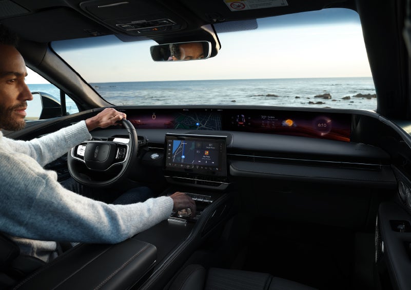 A driver of a parked 2024 Lincoln Nautilus® SUV takes a relaxing moment at a seaside overlook while inside his Nautilus. | Bondy's Lincoln in Dothan AL