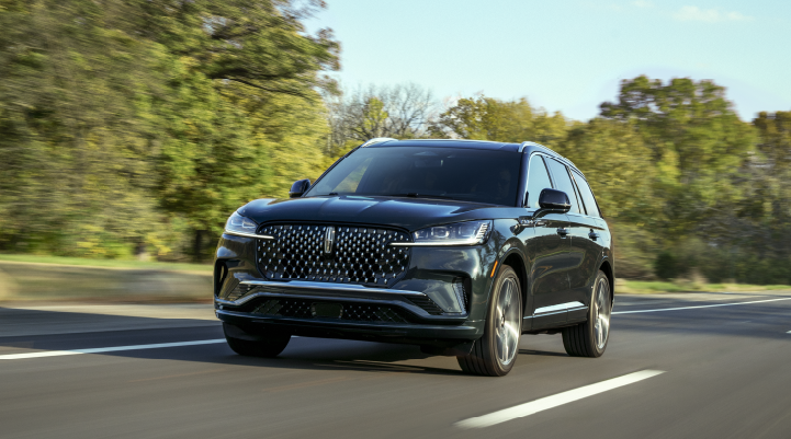 A 2025 Lincoln Black Label Aviator® SUV is being driven down a road lined with trees. | Bondy's Lincoln in Dothan AL