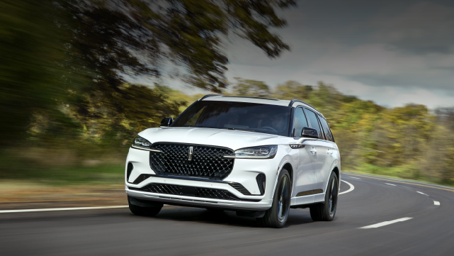 A white 2025 Lincoln Aviator® SUV is being driven down a road lined with trees. | Bondy's Lincoln in Dothan AL