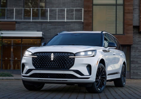 A 2026 Lincoln Aviator® Reserve model is shown with the available Jet Appearance Package parked near a restaurant. | Bondy's Lincoln in Dothan AL