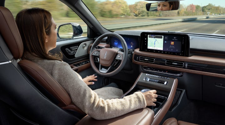 A 2026 Lincoln Aviator® SUV is being driven hands-free on a highway near a forest | Bondy's Lincoln in Dothan AL