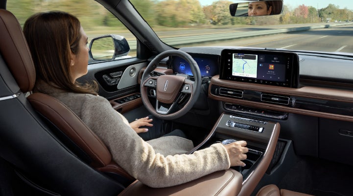 A 2027 Lincoln Aviator® SUV is being driven hands-free on a highway lined with trees. | Bondy's Lincoln in Dothan AL
